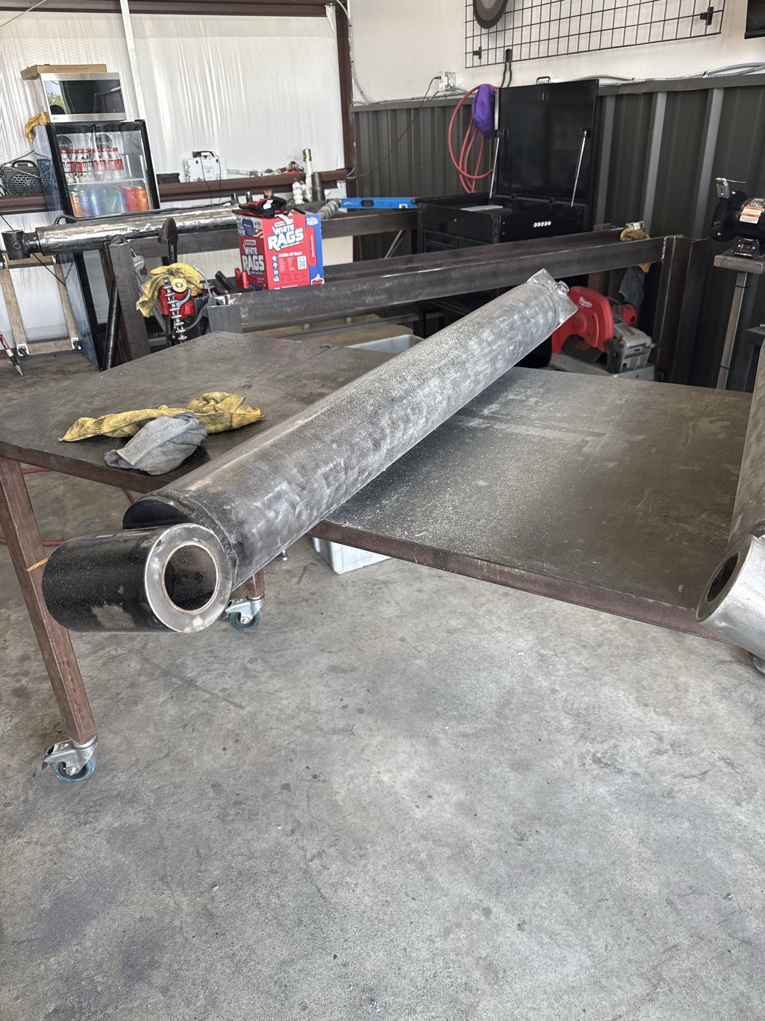 Hydraulic cylinder barrel staged on a shop table