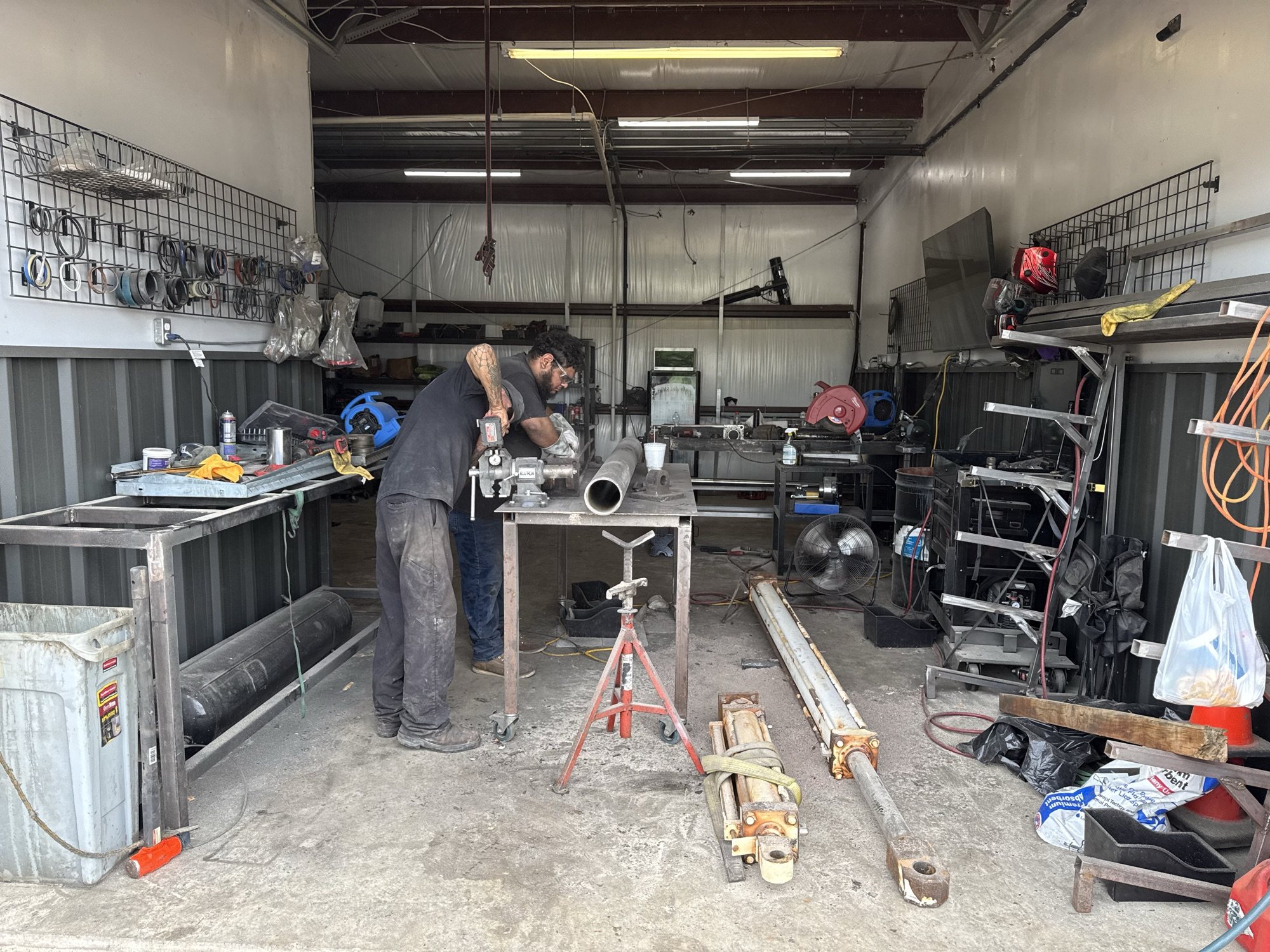 Technicians servicing hydraulic parts in the repair bay