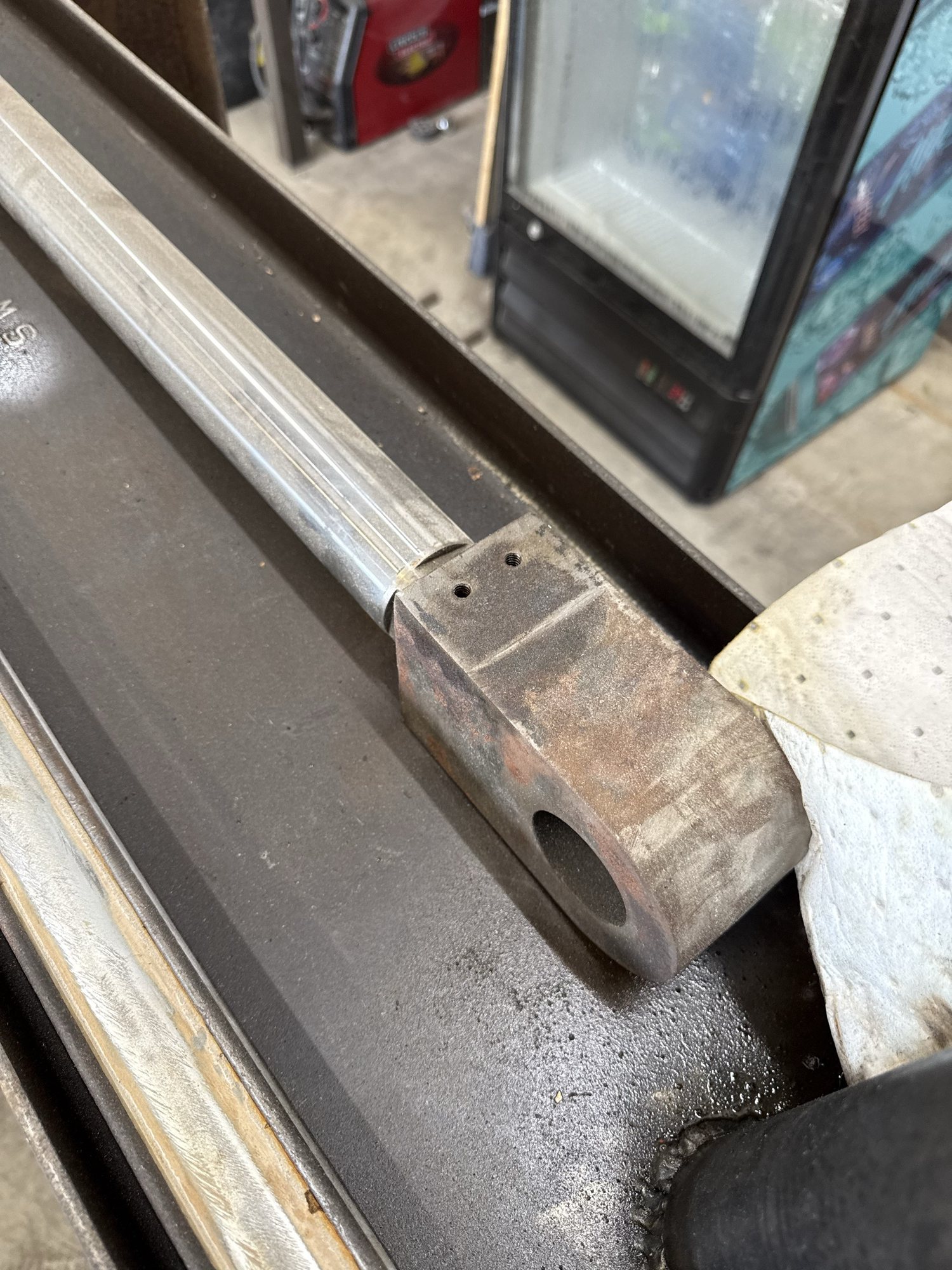 Close-up of a worn hydraulic cylinder end and chrome rod